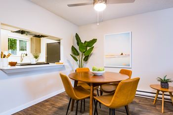 A dining room with a round table and chairs.